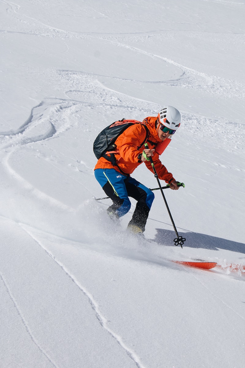 a man riding skis down a snow covered slope