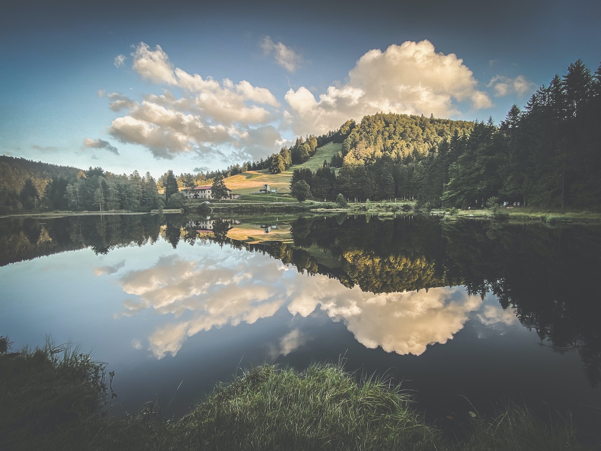 Beautiful clouds reflection in water of Lispach lake in the La Bresse, Vosges