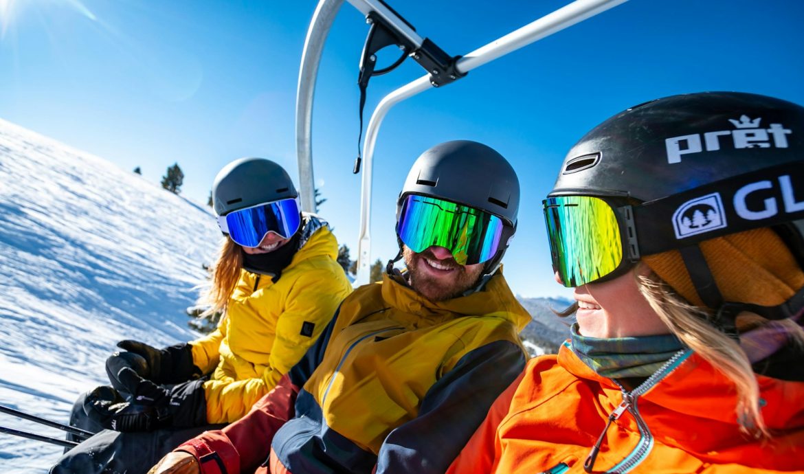 2 person in yellow jacket wearing helmet riding on cable car during daytime